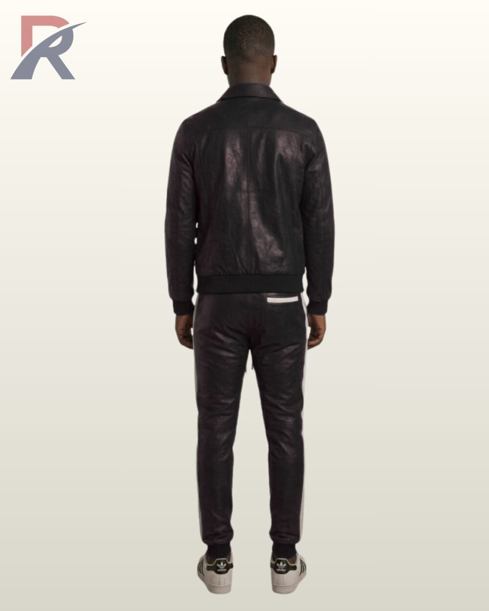 A man wearing a classic black leather tracksuit with white side stripes.