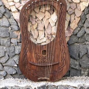 10-string carved wooden lyre harp with dark stain, steel strings, silver tuning pegs, and traditional Celtic relief carvings.