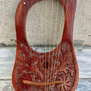 Carved 10-string wooden lyre harp with a rich reddish stain, displaying brass string eyelets, curved bridge, and floral relief carvings.