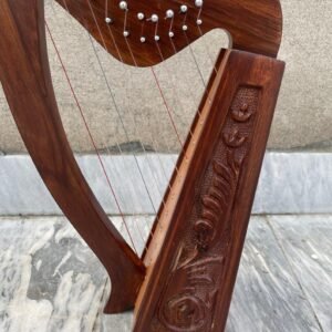 Handmade rosewood leverless Celtic folk harp featuring intricate floral wood carvings, curved pillar, and multicolored strings.
