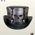 Front view of a black leather steampunk top hat featuring silver printed skull graphics around the crown and small metallic skull studs on the band.
