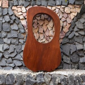 Full rear view of a 10-string handcrafted solid rosewood lyre harp resting against a stone wall, showcasing natural reddish-brown wood grain.