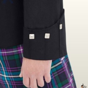 Detailed view of cuff stitching and silver diamond button embellishments on a formal men's black wool highland kilt jacket.