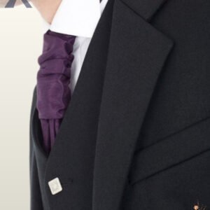 Detailed shot of notched lapel tailoring and square silver buttons on a formal men's black wool Argyle kilt jacket.