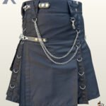 Heavy-duty charcoal grey cotton canvas kilt styled with leather accent straps, silver snaps, and metallic chain draping.