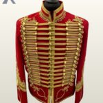 Front view of a red hussar military tunic jacket with extensive gold braiding, brass buttons, and standing collar.
