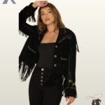 Front view of a model wearing an open black suede western fringe jacket featuring brass buttons, studded chest yokes, and studded cuff trim.