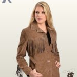Angled front view of a blonde model posing in a women's medium brown suede western fringe jacket with hands near pockets.