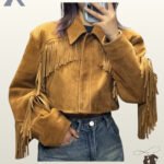 Mirror selfie of a person wearing a women's camel suede cropped western fringe jacket with high-waisted denim jeans.