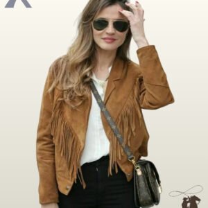 Front view of a model wearing a women's camel suede western fringe jacket paired with a white shirt, aviator sunglasses, and black jeans.