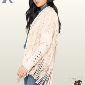 Side profile of a model wearing a women's cream off-white suede western jacket featuring bone pipe beads, silver studs, and long sleeve fringe.