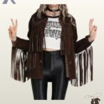 Front view of a model wearing an open dark brown suede western fringe jacket styled with a graphic crop top and black leather pants.