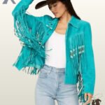 Front view of a model wearing a women's turquoise suede western jacket with bone-beaded fringe, styled with a brown cowboy hat and light jeans.